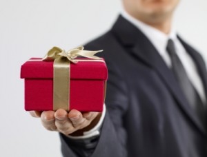 Man in suit holding a gift wrapped present