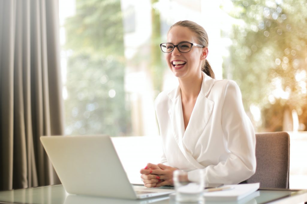 woman smiling at a work desk