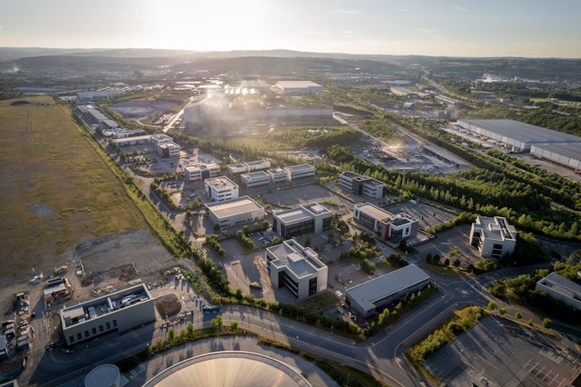 An overhead drone view across the length of the Bristol and Bath Science Park business and technology park at dawn. The sun is peeking up over the low hills on the horizon in the distance. Image at PrimeOfficeSpace.co.uk.