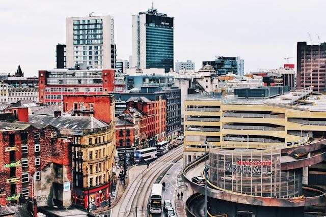 A daytime, overcast view from a high rooftop in central Manchester towards both modern skyscrapers and historical buildings. Image at PrimeOfficeSpace.co.uk.